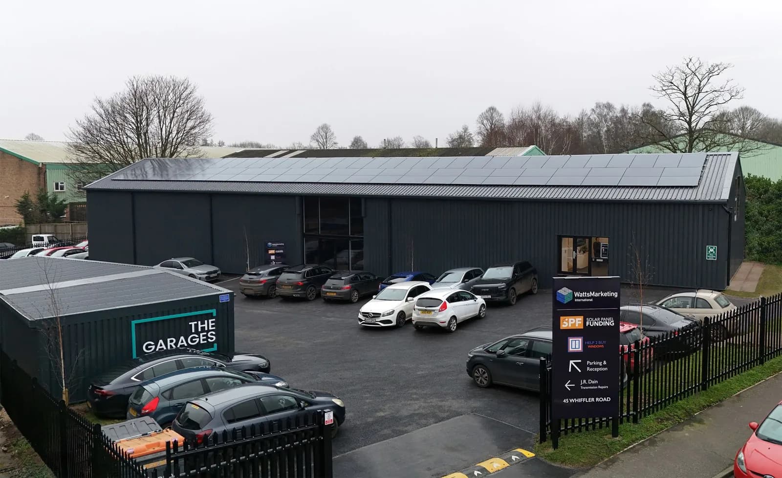 Watts Marketing’s Norwich office at 45 Whiffler Road, seen from above: a dark-clad building with solar panels across the roof and the staff car park in front.